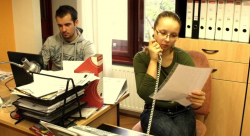 Két hallgató az irodában a telefon és laptop előtt